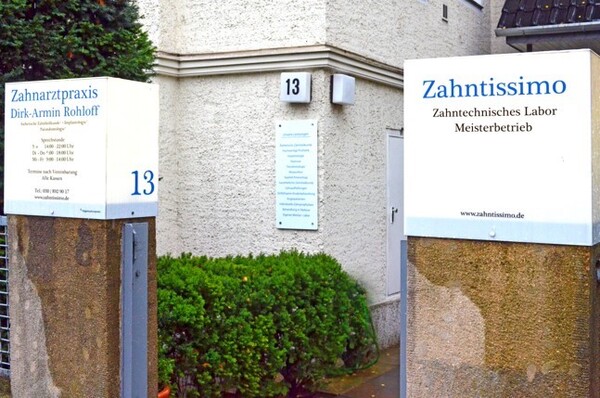 Eingangsbereich mit Schildern einer Zahnarztpraxis und eines zahntechnischen Labors.